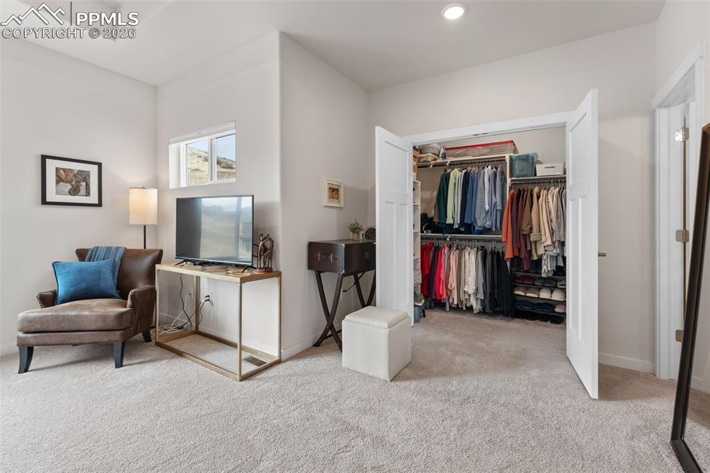 Image 18 of 42: Sitting area and closet #1 in primary suite