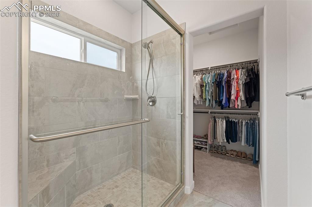 Image 20 of 42: Large shower with seat and closet #2 in primary suite