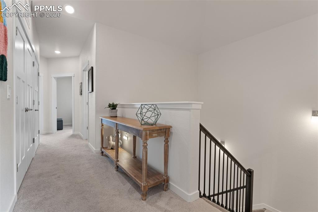 Image 22 of 42: Upstairs hallway has vaulted ceiling and is open to the entry for a spaciao