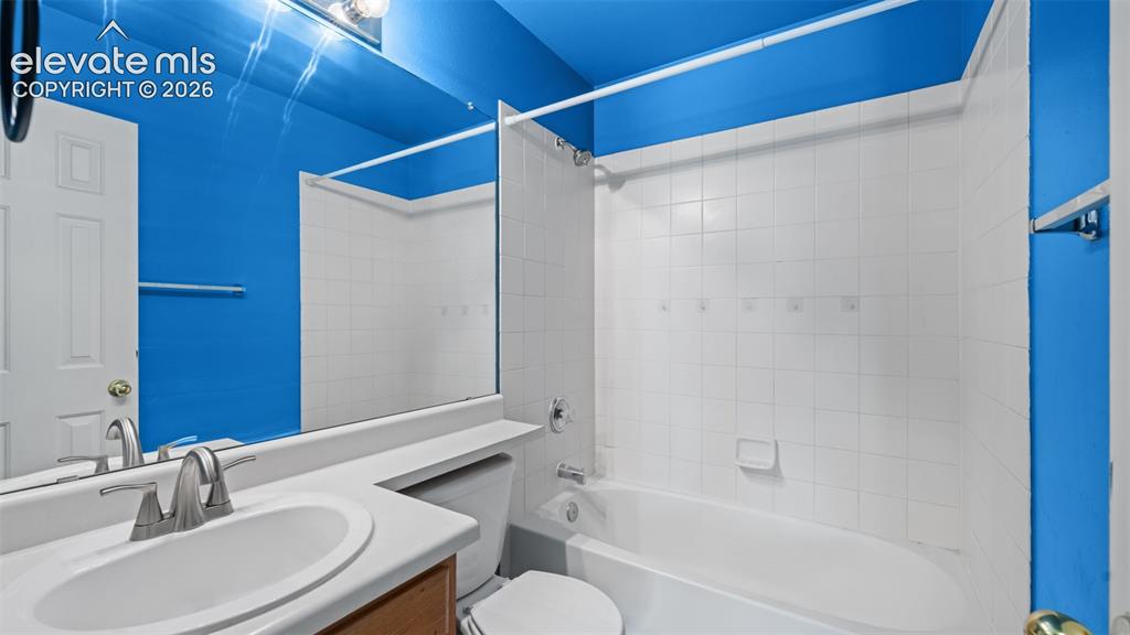 Image 15 of 33: Bathroom featuring a vanity with an integrated sink, a large wall-mounted m