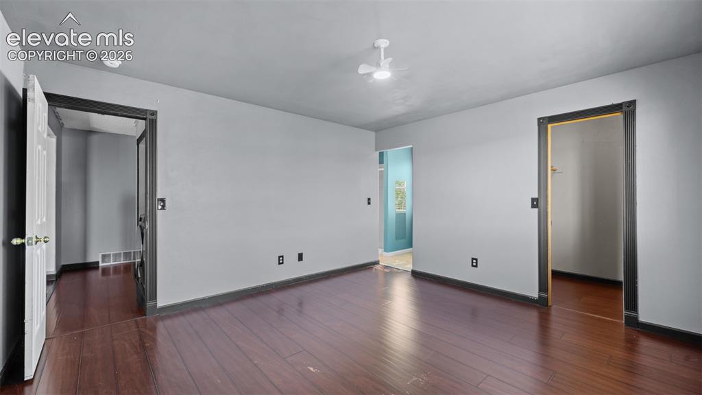 Image 17 of 33: Room featuring wood-finish flooring, light grey painted walls, and white tr