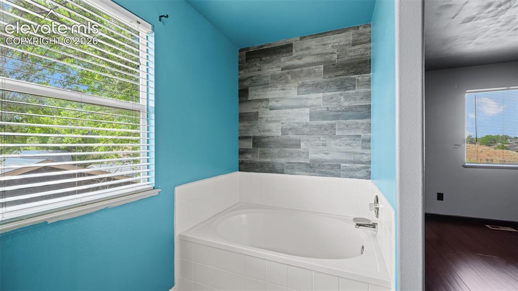 Image 19 of 33: Bathroom featuring a built-in tub with white subway tile surround, a single