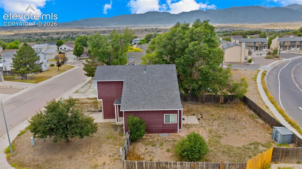 Image 28 of 33: Maroon siding exterior with a dark gray shingle roof