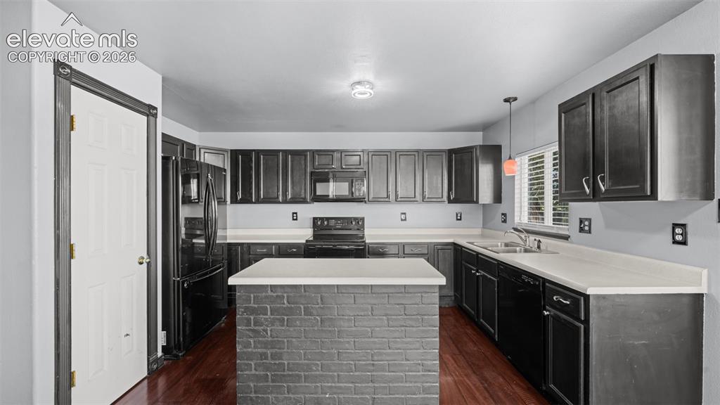 Image 7 of 33: Living area featuring wood-finish flooring, a white tiled fireplace with a 