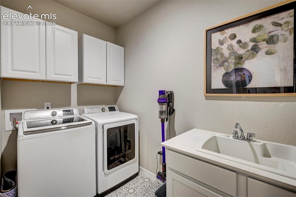 Image 15 of 29: White cabinetry, patterned floor tiling, utility sink, and a built-in count