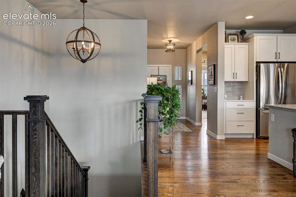 Image 16 of 29: Hardwood flooring, dark wood newel posts, and balusters, with a contemporar