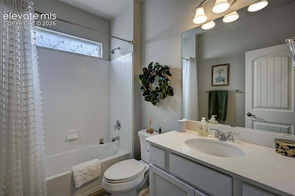 Image 19 of 29: White vanity with an integrated sink, polished chrome faucet, and overhead 