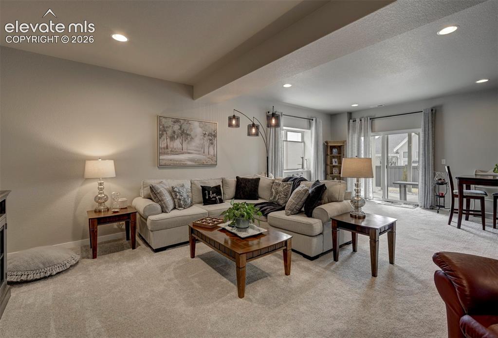 Image 20 of 29: Recessed lighting, light-colored carpeting, and a glass-paneled sliding doo