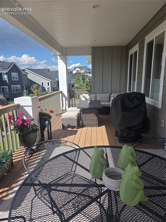 Image 25 of 29: Covered outdoor balcony featuring composite decking, white railing, recesse