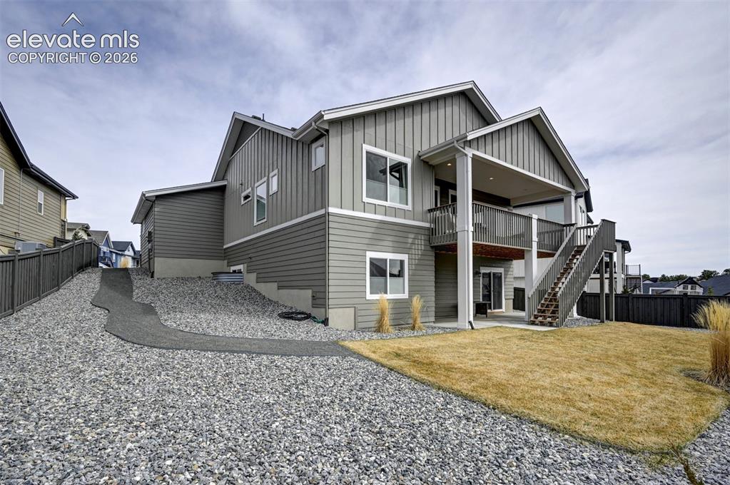 Image 27 of 29: Gray siding exterior with multi-level covered deck, privacy fencing, and gr