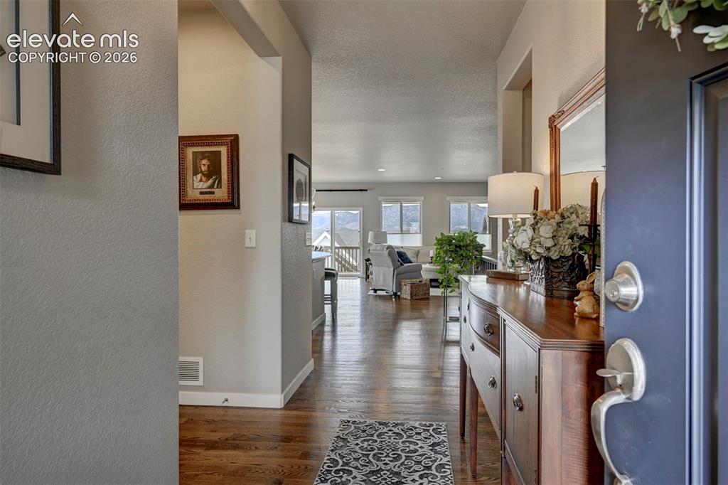 Image 4 of 29: Wood-finish flooring throughout, light-colored wall paint, and vaulted ceil
