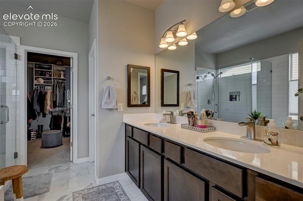 Image 7 of 29: Double vanity with white countertops and dark wood-finish cabinetry