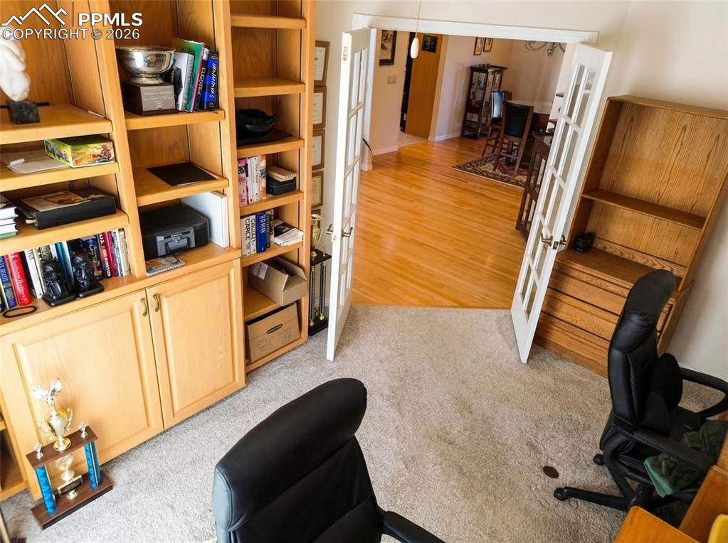 Image 13 of 30: Office space with french doors and light carpet