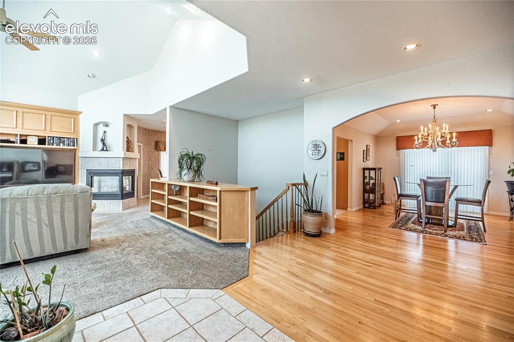 Image 14 of 50: Open-concept living area featuring a corner fireplace with tile surround, b