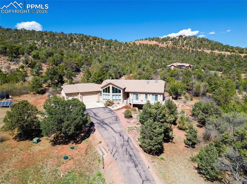 Image 2 of 30: Aerial view of property and surrounding area featuring a heavily wooded are