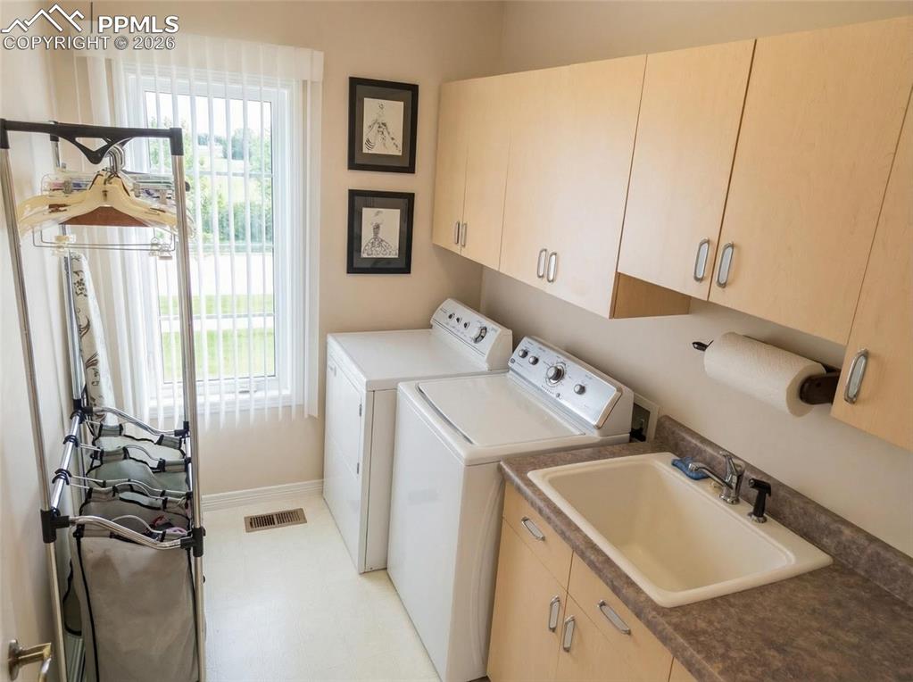 Image 21 of 30: Laundry room featuring cabinet space, washer and clothes dryer, and light f