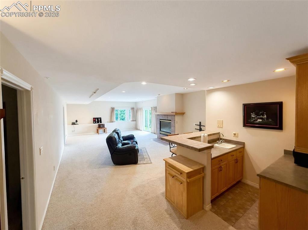 Image 23 of 30: Kitchen featuring a peninsula, open floor plan, light colored carpet, a fir