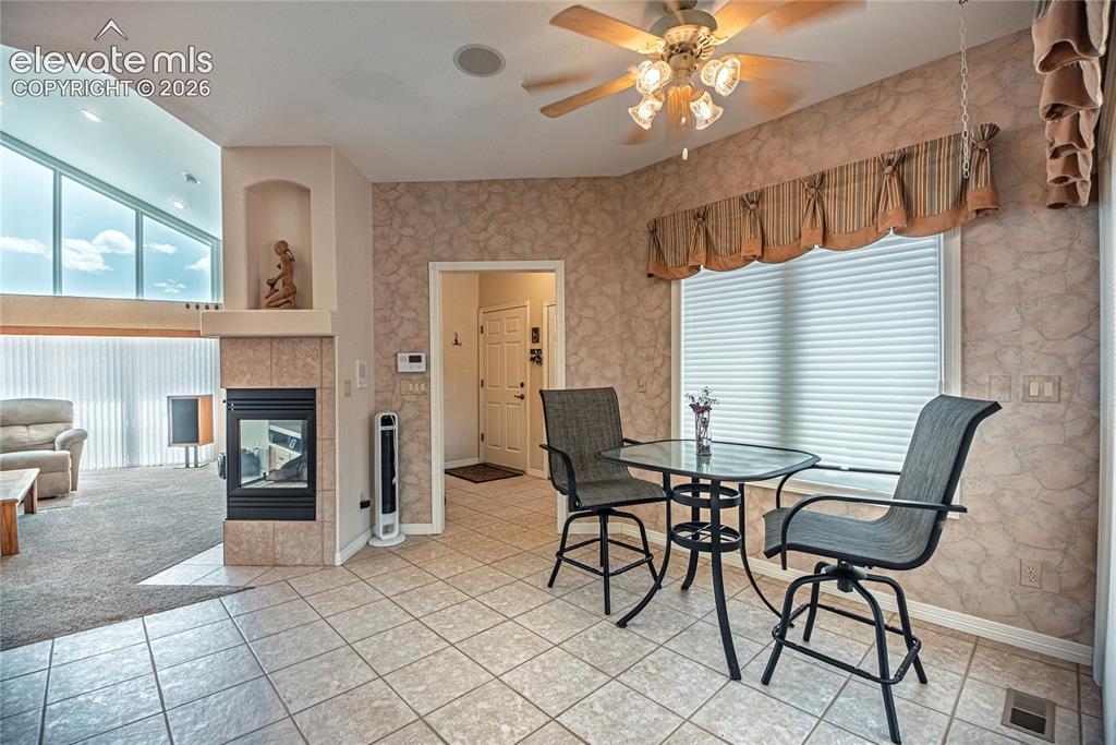 Image 23 of 50: Tiled flooring extends into a space featuring a window with cellular blinds