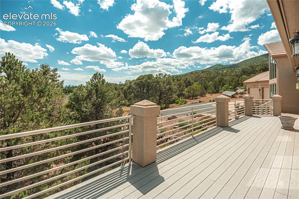 Image 3 of 50: Expansive outdoor deck featuring composite flooring and a horizontal bar ra