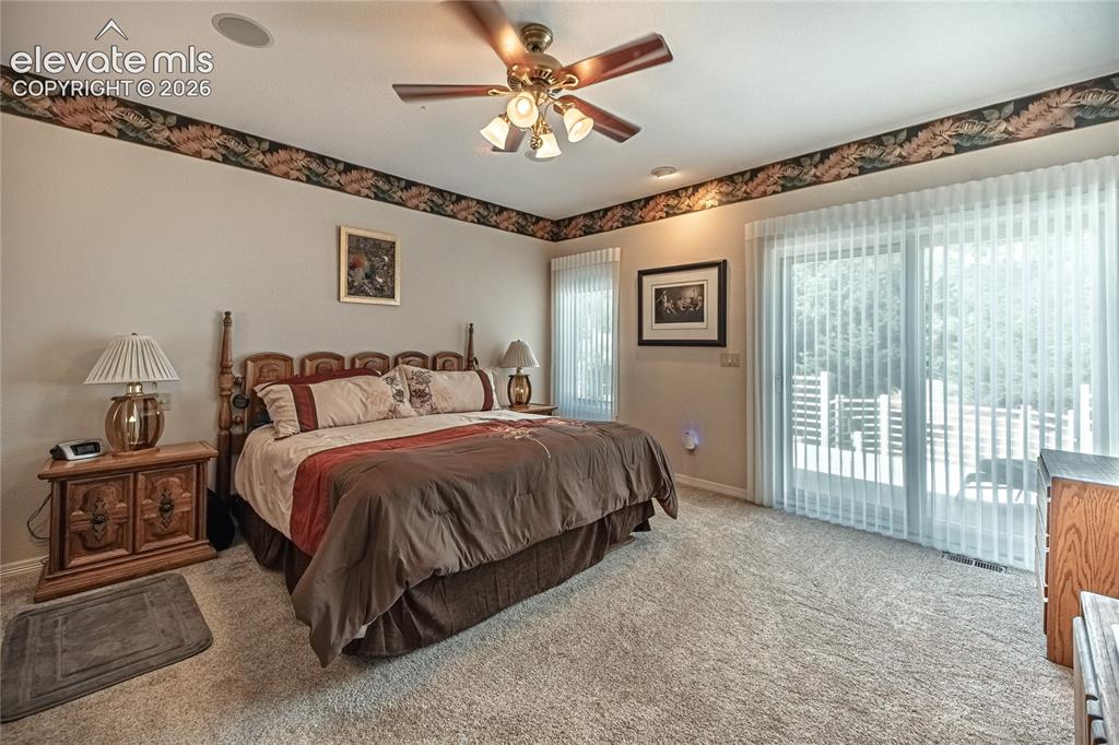 Image 31 of 50: Carpeted room featuring a ceiling fan with integrated lighting, sliding gla