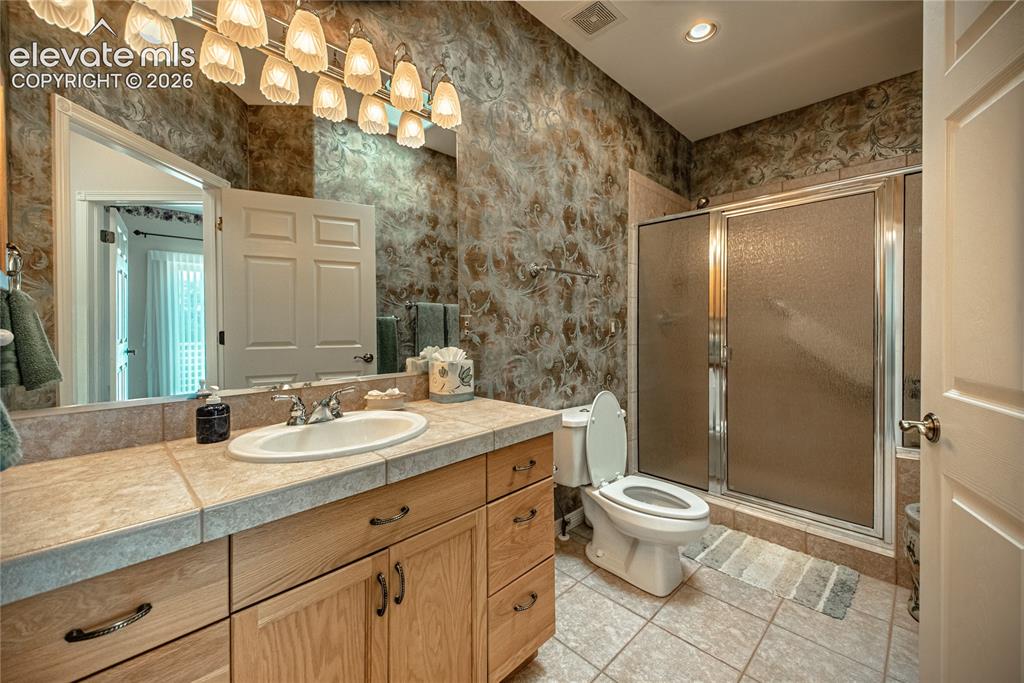 Image 35 of 50: Bathroom featuring a spacious vanity with an integrated sink and tile count
