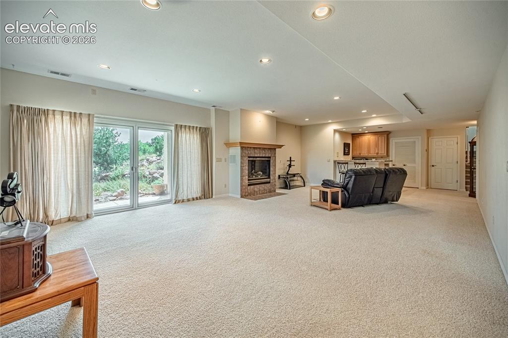 Image 41 of 50: Spacious recreation area featuring light-toned carpeting and recessed light