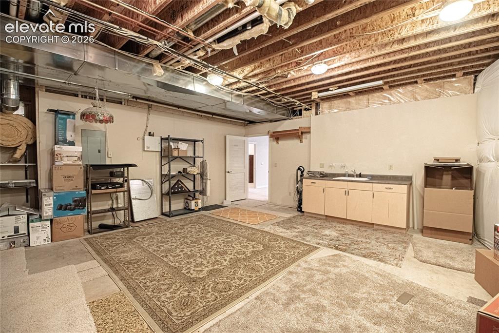 Image 43 of 50: Unfinished basement featuring exposed wood joists and ductwork, a built-in