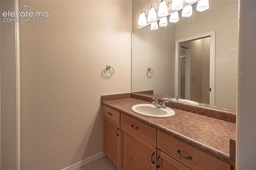 Image 45 of 50: Bathroom vanity featuring a light wood-finish cabinet with multiple drawers