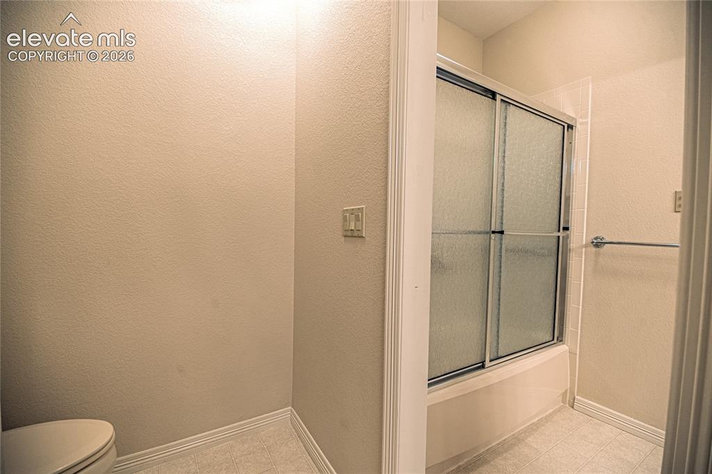Image 46 of 50: Tub and shower combination featuring sliding frosted glass doors