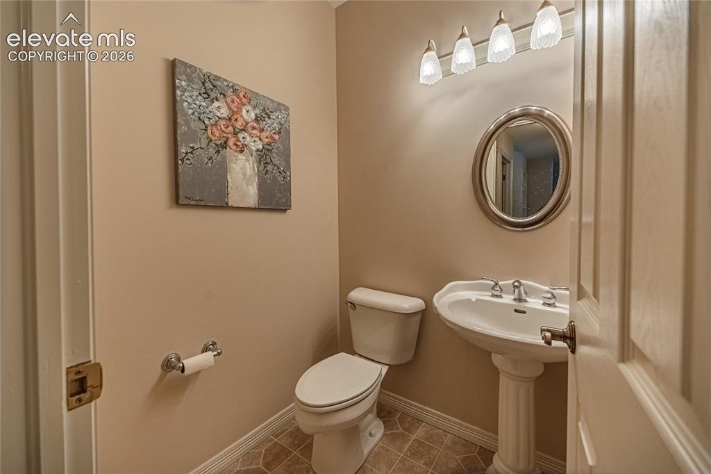 Image 50 of 50: Pedestal sink with dual-handle faucet, oval mirror, and a four-light vanity