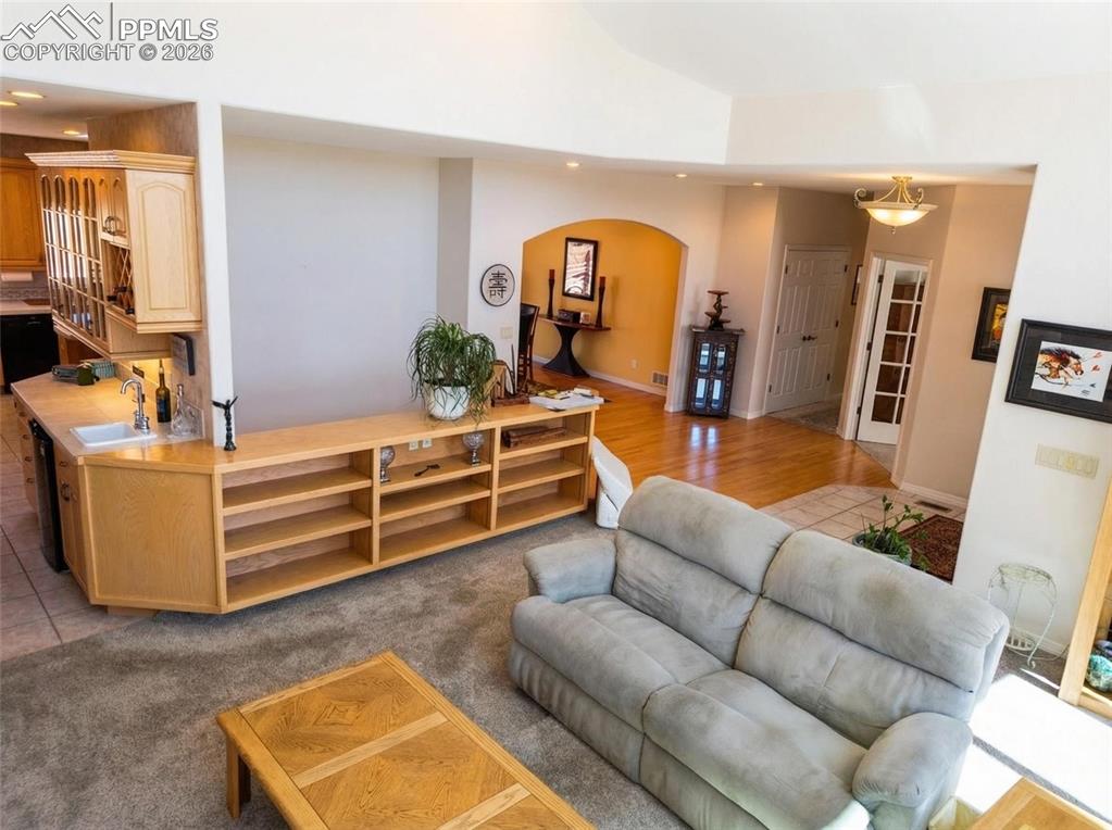 Image 6 of 30: Living area with recessed lighting, light colored carpet, arched walkways, 