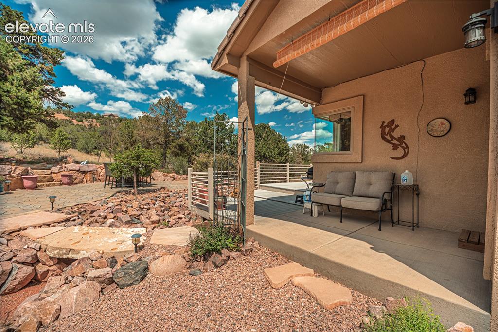 Image 6 of 50: Covered concrete patio with stucco exterior, featuring a rectangular window