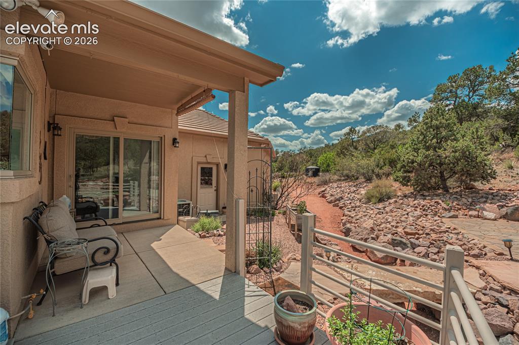 Image 8 of 50: Covered patio with a concrete slab, wood-finish decking, and sliding glass