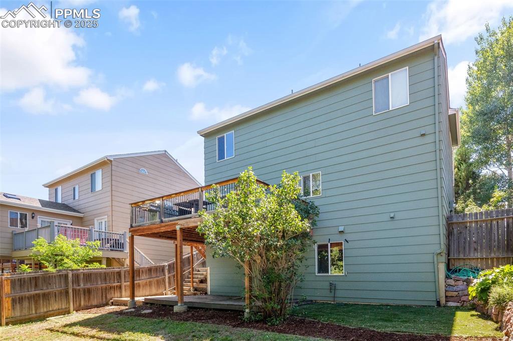 Image 34 of 46: Rear view of house featuring a fenced backyard, a deck, and stairway