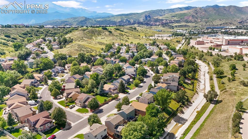 Image 37 of 46: Aerial view of residential area featuring a mountainous background