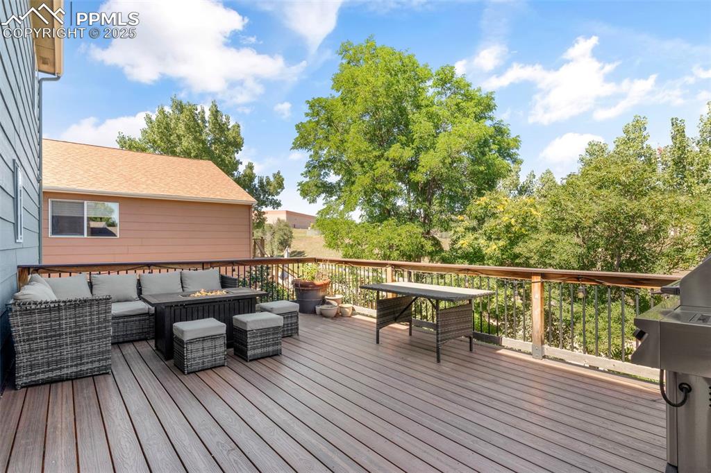 Image 7 of 46: Wooden terrace with outdoor lounge area and a grill