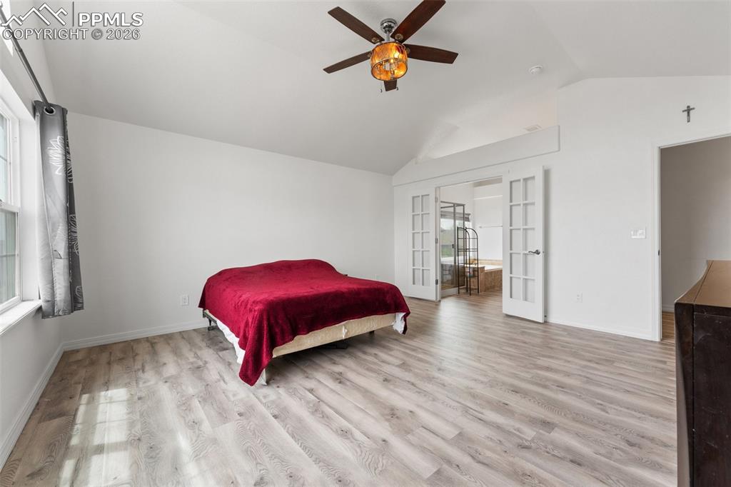 Image 20 of 50: Primary Bedroom with Vaulted Ceiling, French Doors for En-suite and Walk-In