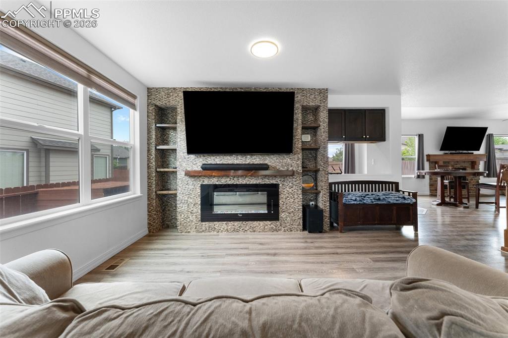 Image 7 of 50: Main Level Living Room with Electric Fireplace and Built-In Shelving