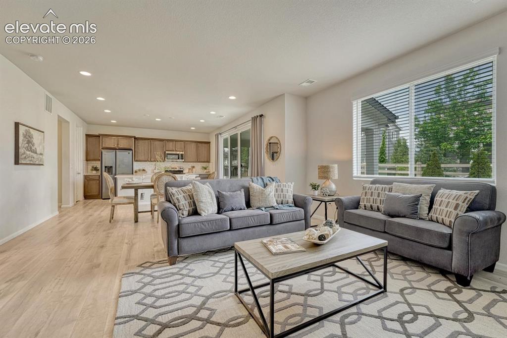 Image 13 of 50: The family room centers around a gas fireplace with a striking floor-to-cei