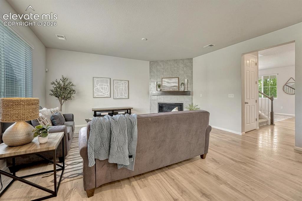 Image 15 of 50: Stunning gas fireplace with floor to ceiling stone surround.