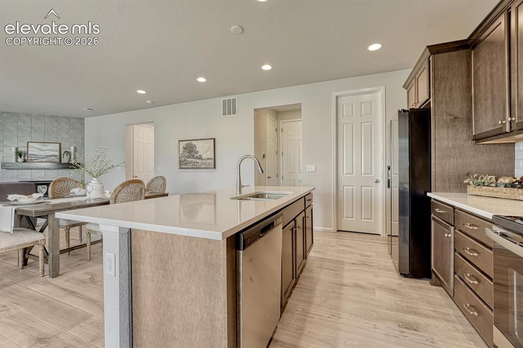 Image 18 of 50: Island Kitchen with breakfast bar, pantry, and garage access.
