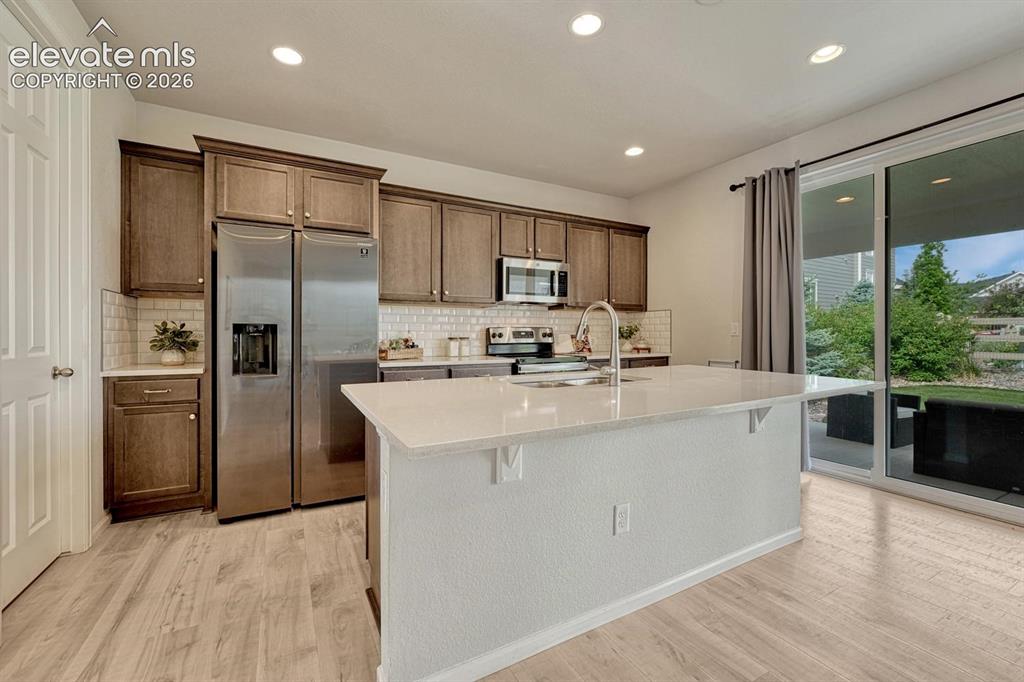 Image 21 of 50: View of the Kitchen, Dining Area and Family Room.
