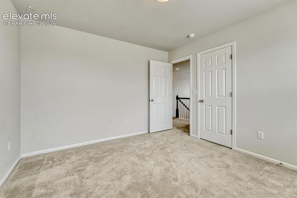 Image 39 of 50: Upper Level Bedroom #3 with neutral carpet.