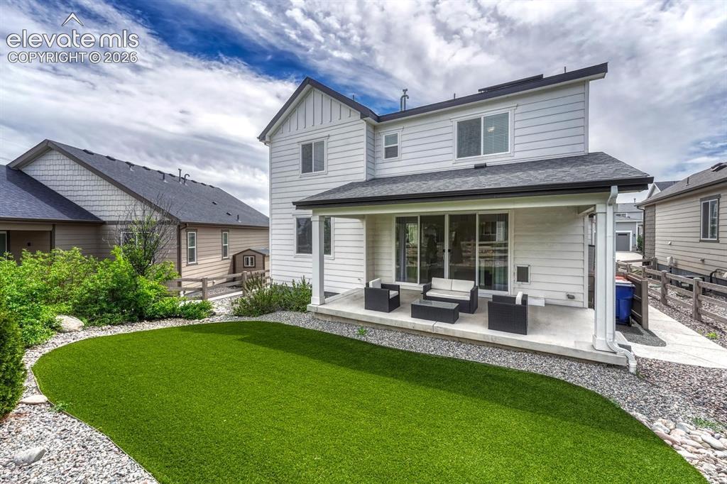 Image 45 of 50: Well manicured backyard with new turf grass, rock gardens with shrubs, and
