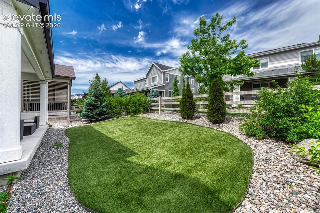 Image 46 of 50: Fenced backyard with covered patio.