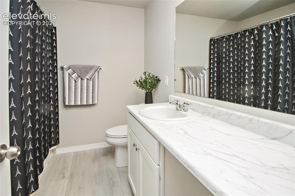 Image 24 of 24: Bathroom featuring a single vanity with an integrated sink, a white counter