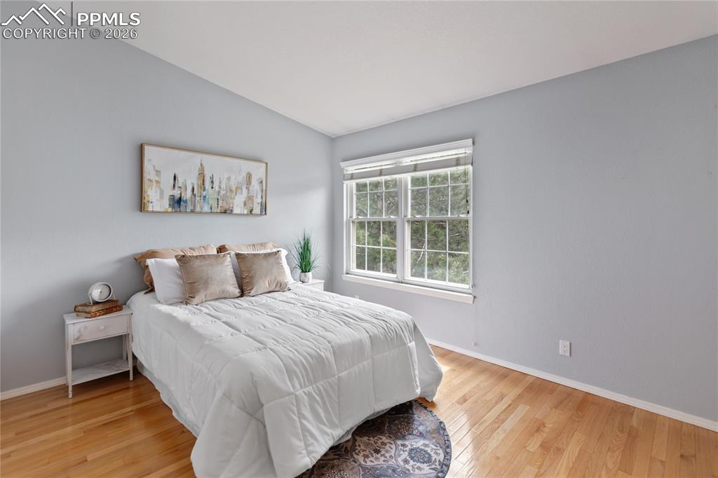 Image 21 of 37: Primary bedroom on the upper level features vaulted ceiling along with real