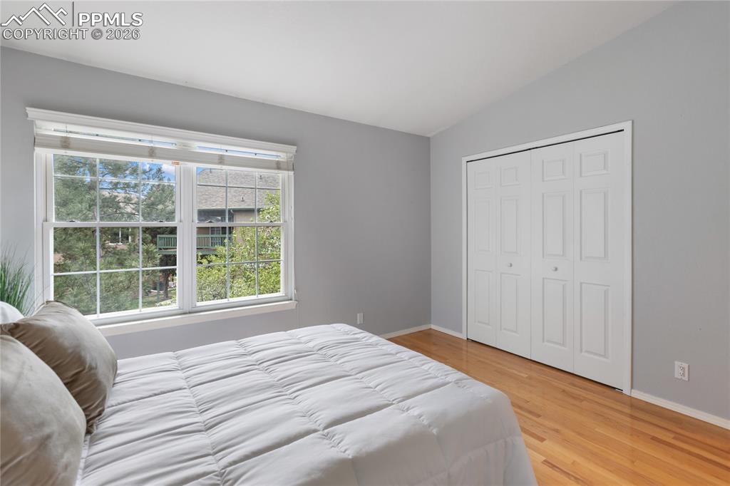 Image 24 of 37: Primary bedroom on the upper level with real wood flooring