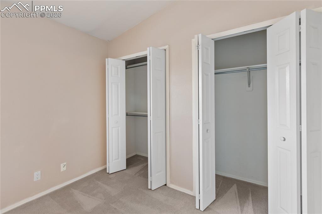 Image 33 of 37: Upper level bedroom features dual closets