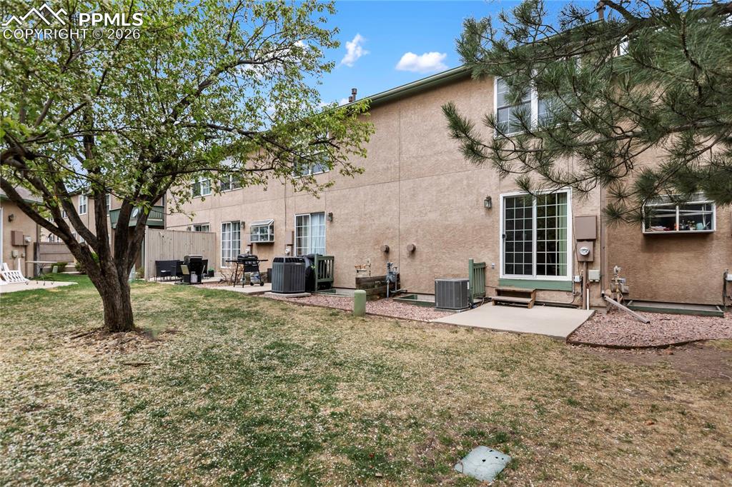 Image 5 of 37: This townhome features a private concrete patio and backs to this grassy ar